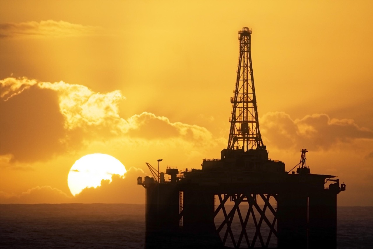 Sun rising behind an oil rig. Drillers.com