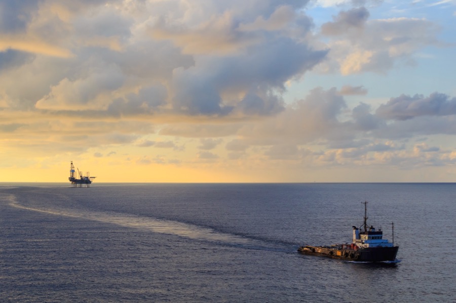 Photo of a jack up rig owned by drilling operators and a service companies supply boat